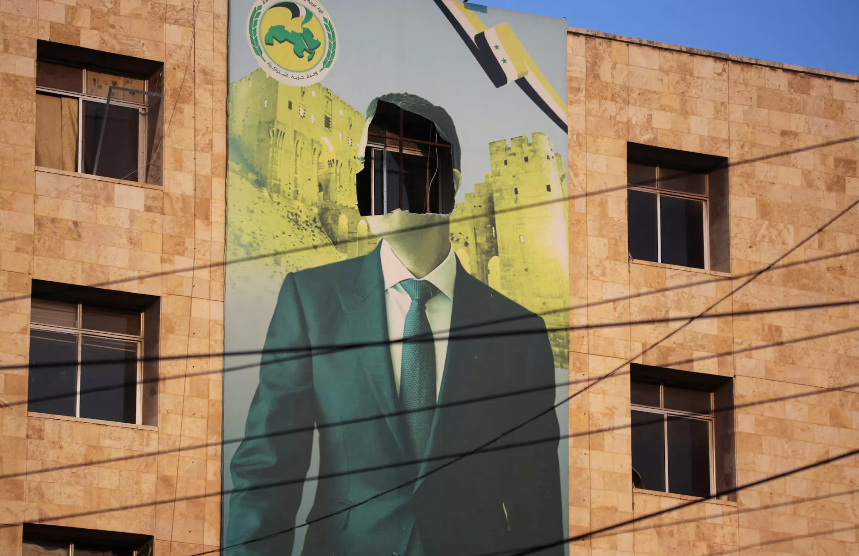 Retrato de Assad danificado após a queda do regime Retrato de Assad danificado após a queda do regime