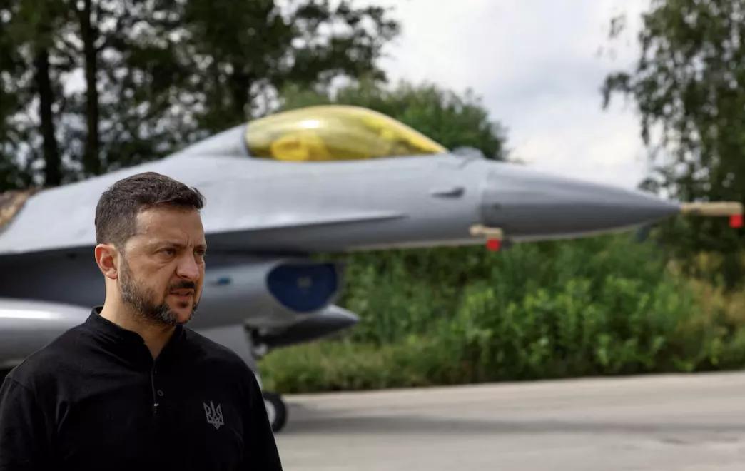 O presidente da Ucrânia, Volodymyr Zelensky, fala à mídia na frente de um avião de combate F-16 O presidente da Ucrânia, Volodymyr Zelensky, fala à mídia na frente de um avião de combate F-16