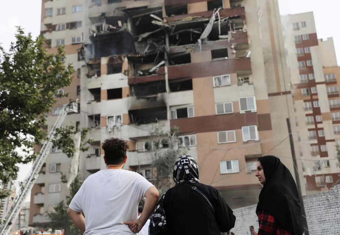 Pessoas observam um prédio danificado após ataques israelenses, em Teerã, Irã, em 13 de junho Pessoas observam um prédio danificado após ataques israelenses, em Teerã, Irã, em 13 de junho