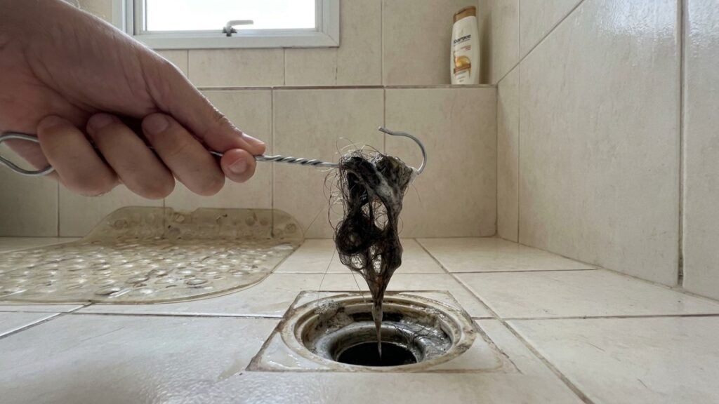 Transformar um cabide de arame em ferramenta de limpeza remove o acúmulo de cabelos sem a necessidade de produtos químicos.