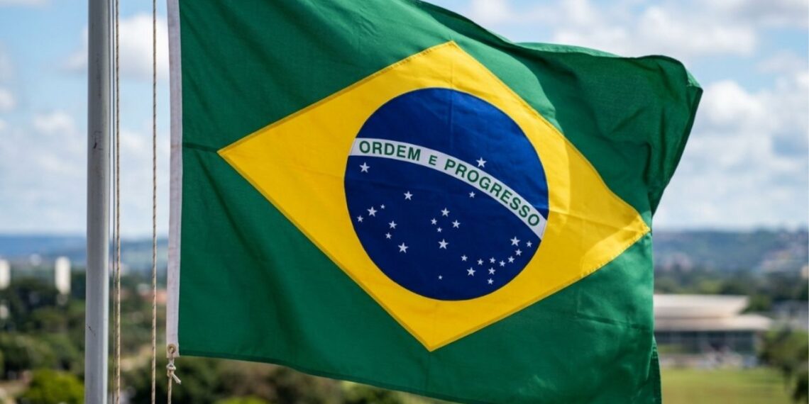 O que significa a frase "Ordem e Progresso" escrita na faixa branca da bandeira do Brasil, e de onde veio essa ideia?
