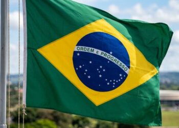 O que significa a frase "Ordem e Progresso" escrita na faixa branca da bandeira do Brasil, e de onde veio essa ideia?