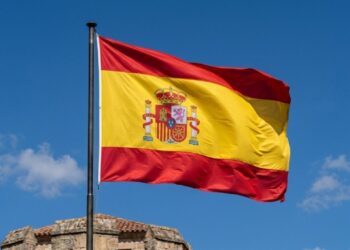 Por que a bandeira da Espanha possui uma faixa vermelha e amarela com um escudo no centro, e o que cada elemento dele representa?
