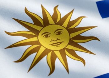 Por que a bandeira do Uruguai possui um sol com rosto humano no canto superior esquerdo, e qual é a origem desse símbolo peculiar?
