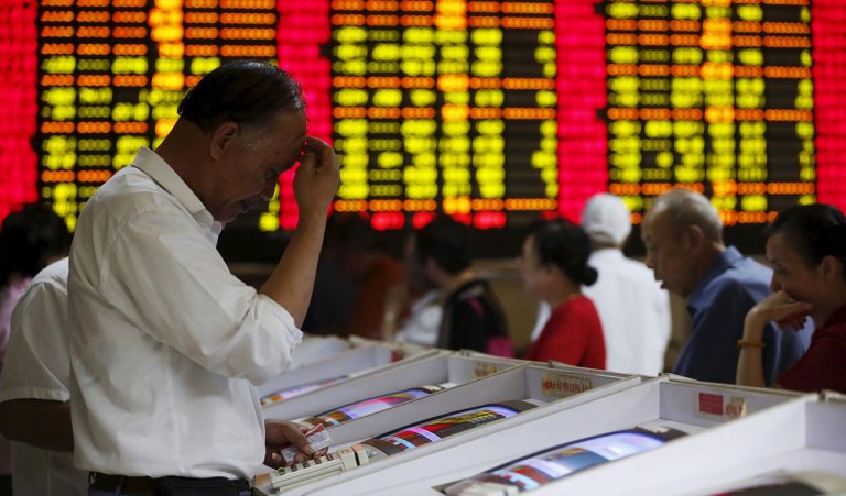 Investors look at computer screens showing stock information at a brokerage house in Shanghai, China 
bolsa china