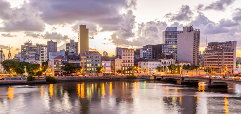 Skyline of Recife in Pernambuco, Brazil showcasing its historic architecture at sunset by the Capibaribe River.