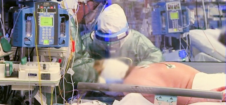 Equipe médica com roupa de proteção trata paciente com coronavírus em UTI de hospital em Cremona, no norte da Itália