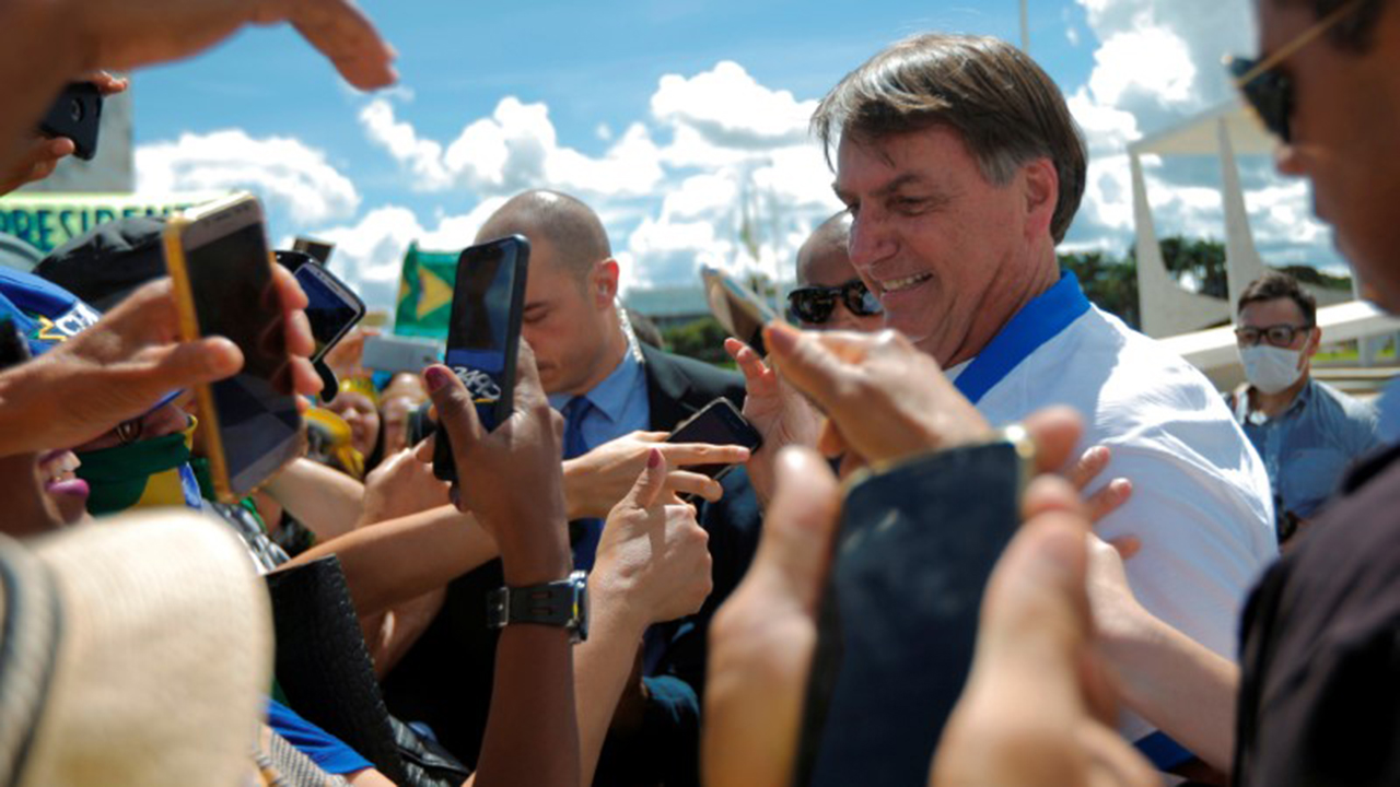 Presidente Jair Bolsonaro cumprimenta apoiadores em frente ao Palácio do Planalto durante manifestação, já em meio à epidemia do coronavírus