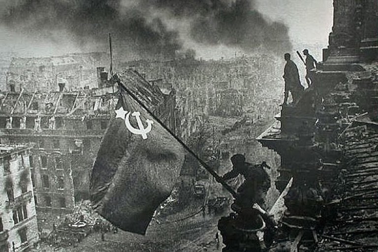 A bandeira soviética içada no telhado do Reichstag, foto histórica de Yevgeny Khaldei