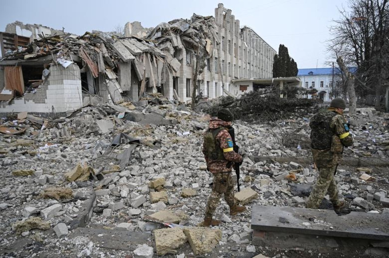 Militares ucranianos caminham perto de um prédio escolar destruído por um bombardeio em Zhytomyr, Ucrânia, em 4 de março de 2022