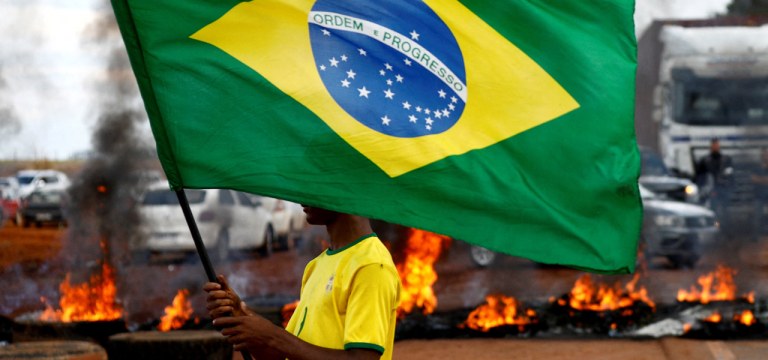 Homem segura bandeira brasileira durante bloqueio na BR-251 em Planaltina 31/10/2022