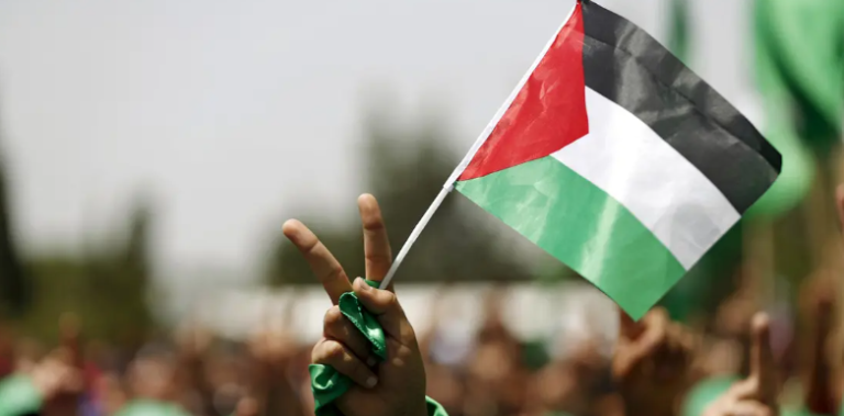 Um estudante que apoia o Hamas segura uma bandeira palestina em um comício na Universidade Birzeit, na cidade de Ramallah, na Cisjordânia ocupada, 26 de abril de 2016