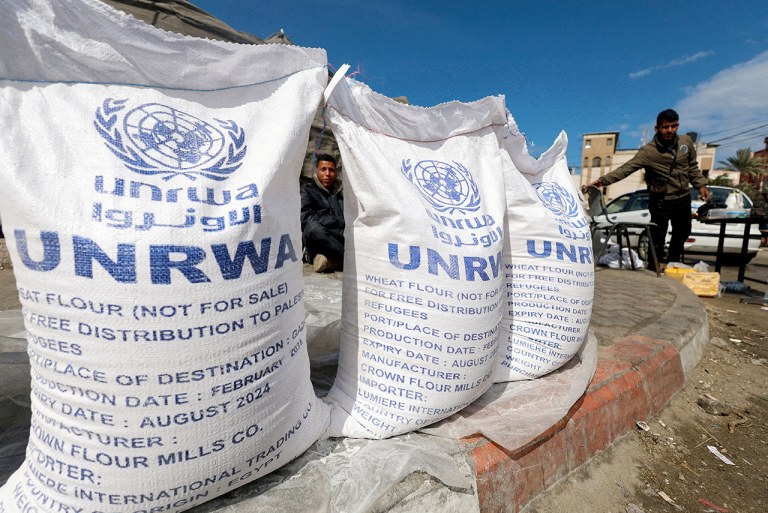 Palestinos deslocados esperam ajuda da Agência de Assistência e Obras das Nações Unidas (UNRWA), em Rafah, no sul da Faixa de Gaza