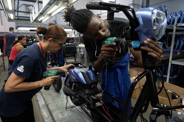 Trabalhadores montam uma scooter na fábrica da Vedca em Havana
