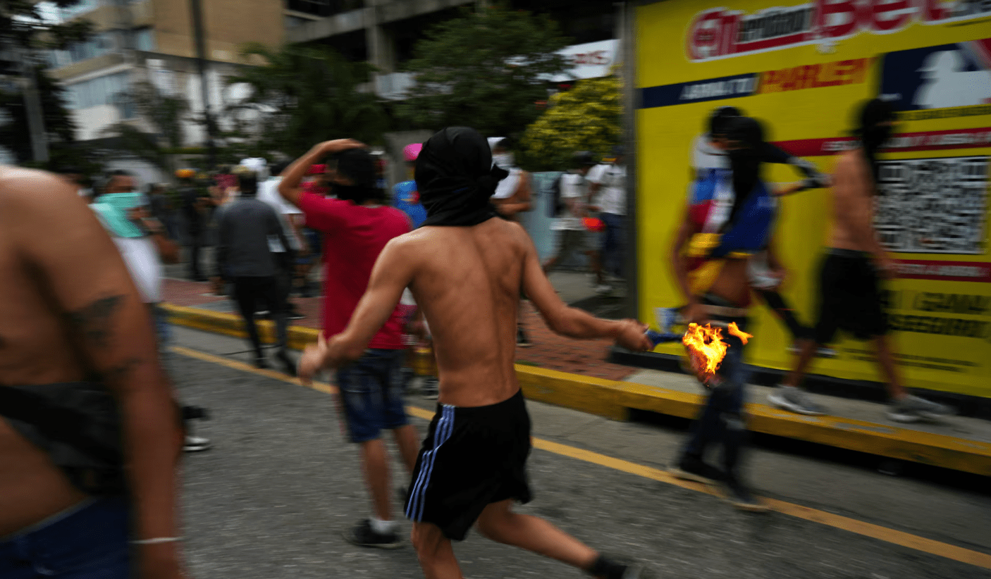 Um manifestante corre com um coquetel molotov enquanto apoiadores da oposição venezuelana protestam após a eleição, em Caracas, Venezuela, 29 de julho