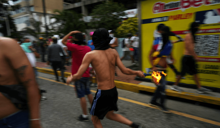 Um manifestante corre com um coquetel molotov enquanto apoiadores da oposição venezuelana protestam após a eleição, em Caracas, Venezuela, 29 de julho