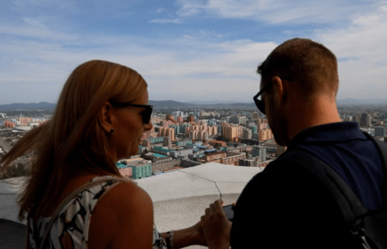 Turistas estrangeiros tiram fotos do horizonte da cidade a partir do mirante da Torre Juche em Pyongyang, Coreia do Norte, em 11 de setembro de 2018