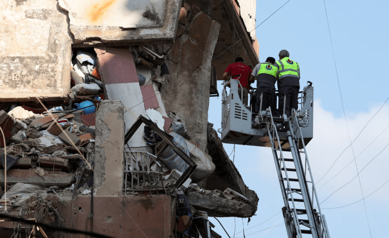 Membros da unidade de defesa civil e combate a incêndios trabalham no local de um ataque israelense nos subúrbios ao sul de Beirute, Líbano, 24 de setembro de 2024