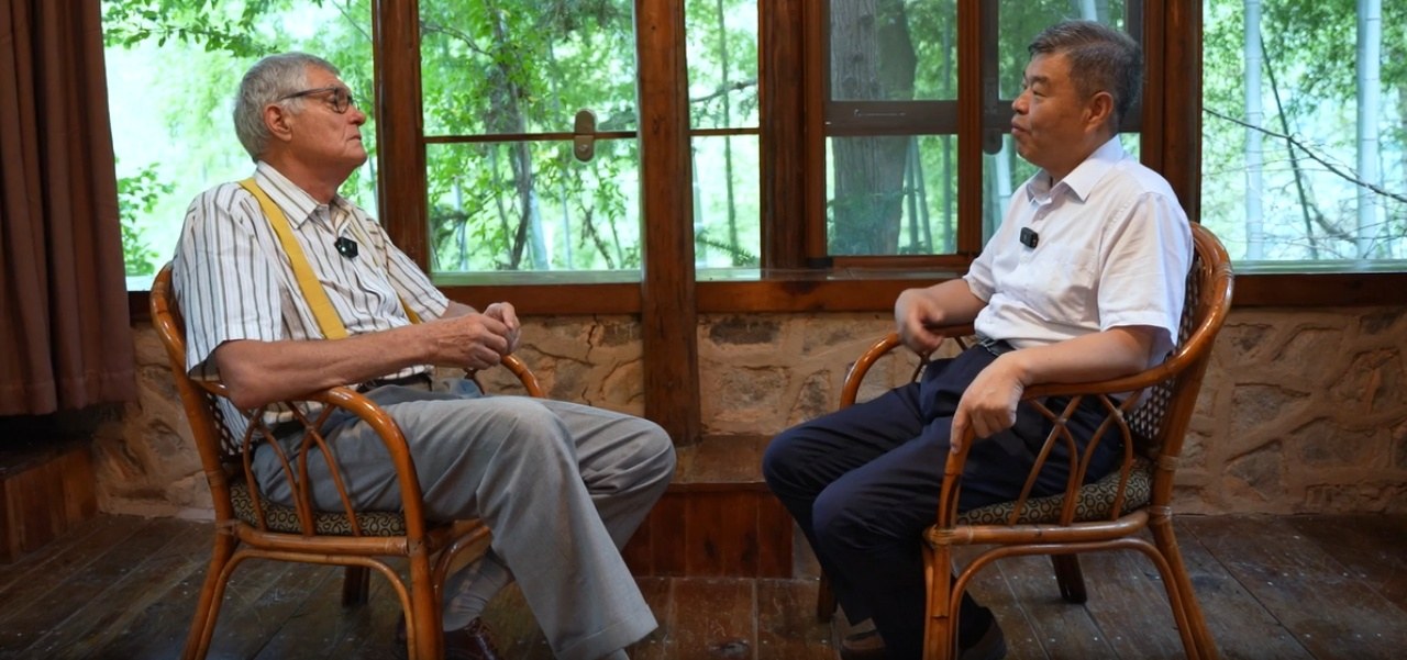 O professor Wang Yuanfeng, diretor do Centro de Pesquisa de Tecnologias e Estratégias de Carbono Neutro da Universidade Jiaotong de Beijing, conversa com Patrick Nijs, ex-embaixador da Bélgica na China