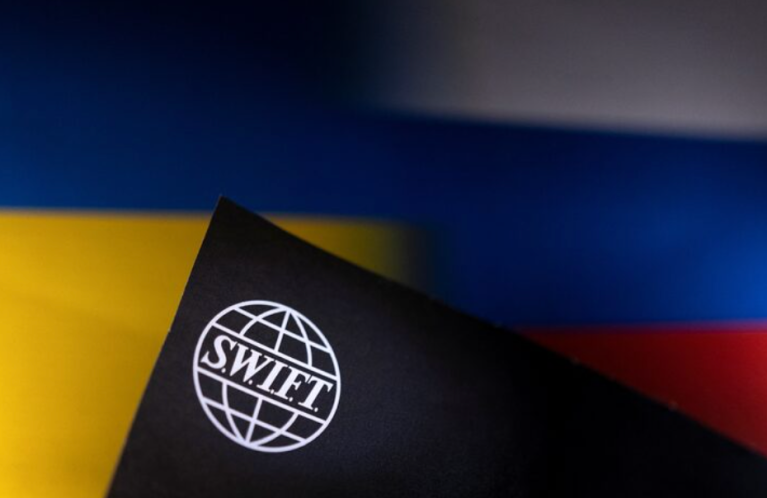 Logo do SWIFT e bandeiras da Ucrânia e da Rússia. Moscou foi excluído do sistema de pagamentos internacional devido à guerra