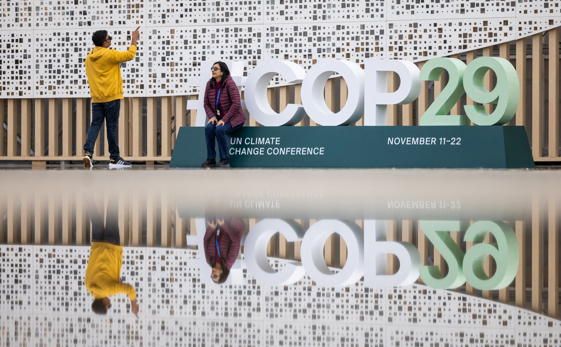 Pessoas tiram fotos na entrada do local da conferência da ONU de mudanças climáticas (COP29), antes do início da cúpula em Baku, Azerbaijão
10/11/2024