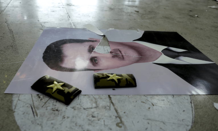 Uma foto danificada de Bashar al-Assad da Síria está no chão dentro do aeroporto internacional de Qamishli, depois que grupos armados sírios anunciaram que haviam derrubado Bashar al-Assad da Síria, em Qamishli, Síria, 9 de dezembro