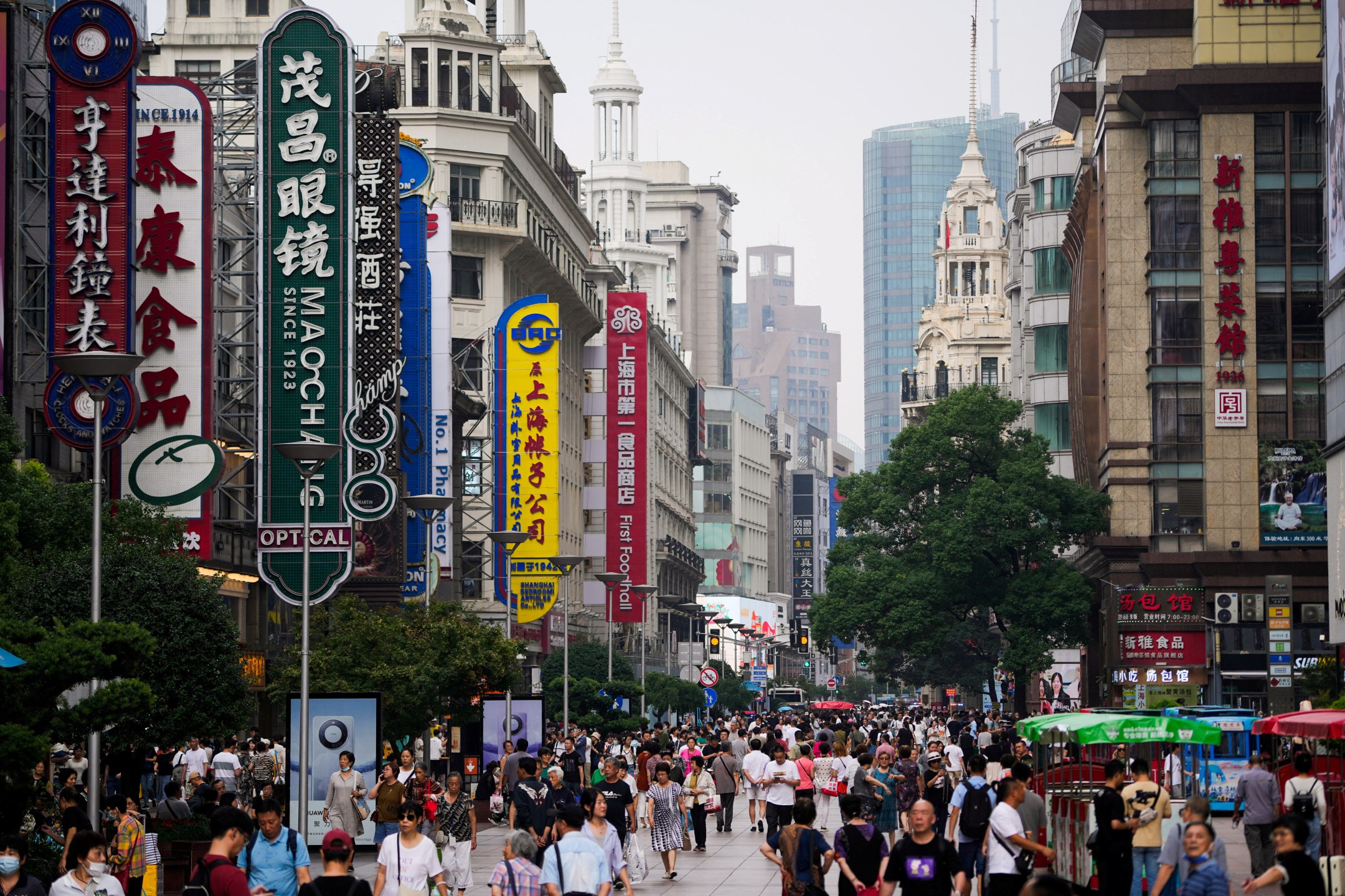 Pessoas caminham pela Nanjing Pedestrian Road, principal área comercial, em Xangai, China