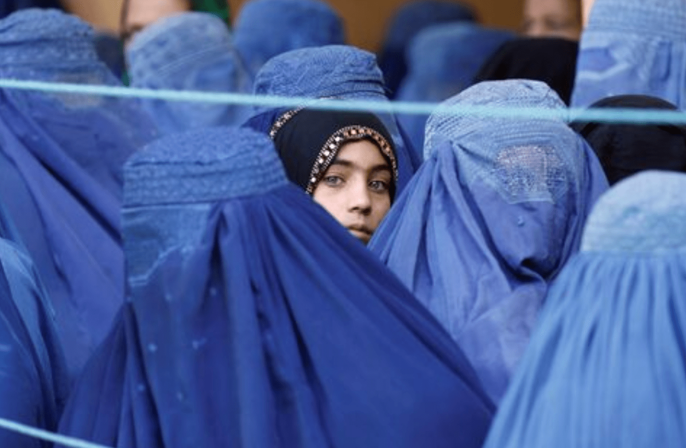 Uma menina observa entre mulheres afegãs que fazem fila para receber assistência humanitária, durante o mês sagrado do Ramadã em Jalalabad, Afeganistão, 11 de junho de 2017