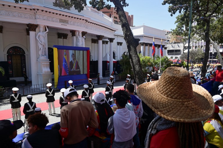 Pessoas acompanham telão em Caracas enquanto presidente da Venezuela, Nicolás Maduro, presta juramento para um terceiro mandato de seis anos - 10/01/2025