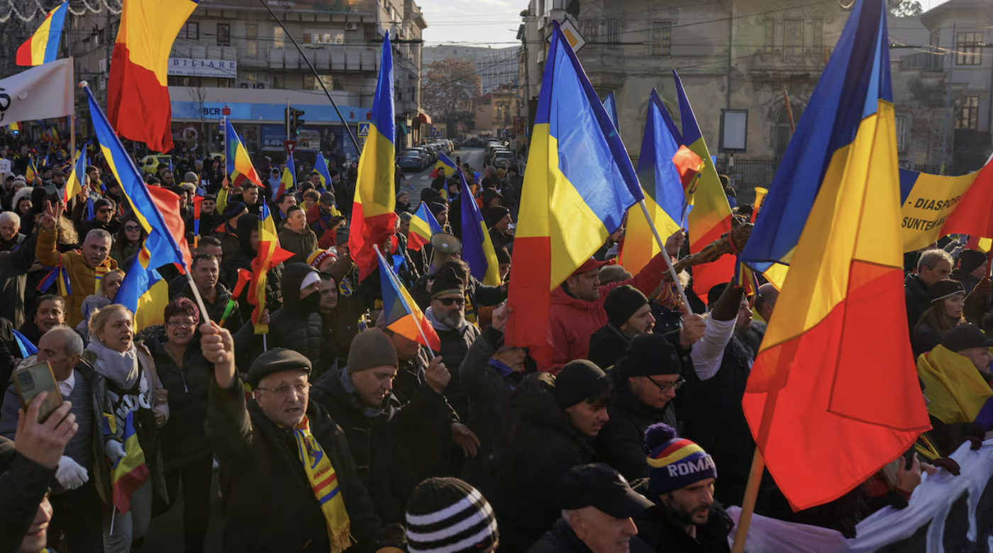 Manifestantes agitam bandeiras nacionais romenas durante uma manifestação em Bucareste, Romênia, 12 de janeiro de 2025