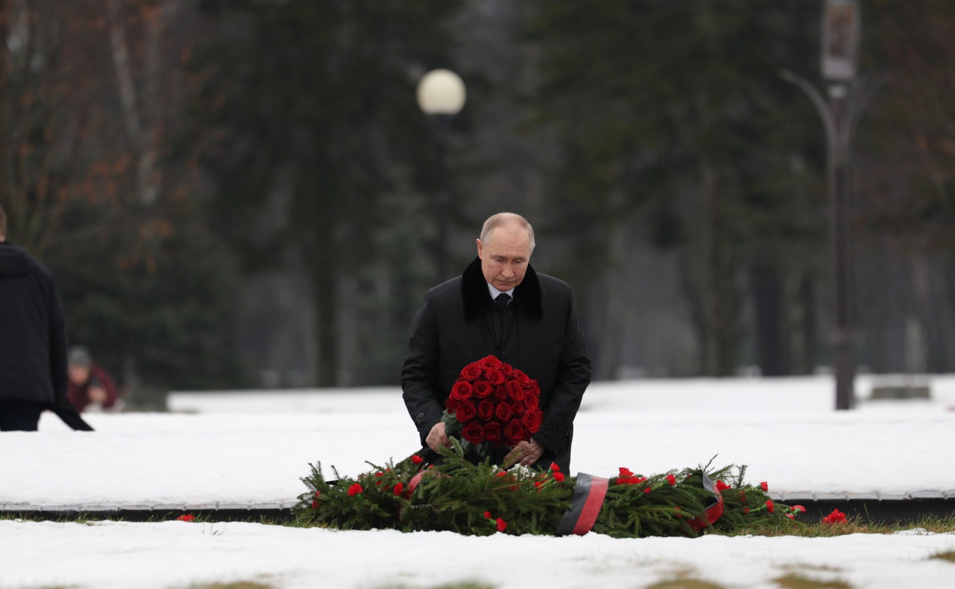 Enquanto caminhava em direção ao monumento à Pátria no Cemitério Memorial Piskaryovskoye, Vladimir Putin deposita flores em uma vala comum, durante os eventos comemorativos que marcam o 81º aniversário do rompimento do cerco de Leningrado