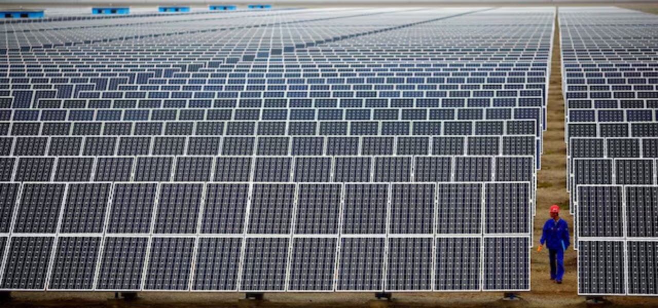 Um trabalhador inspeciona painéis solares em uma fazenda solar em Dunhuang, 950 km a noroeste de Lanzhou, província de Gansu
