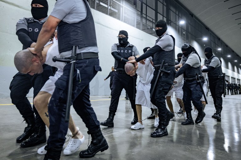 Guardas prisionais salvadorenhos escoltam supostos membros da gangue venezuelana Tren de Aragua e da gangue MS-13 deportados pelo governo dos EUA em Tecoluca, El Salvador, 31/03/2025