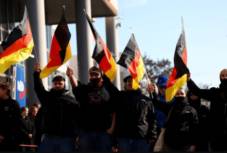 Apoiadores do partido Alternativa para a Alemanha (AfD) agitam bandeiras enquanto participam de um comício de campanha da AfD em Hohenschoenhausen, Berlim, Alemanha, em 22 de fevereiro de 2025