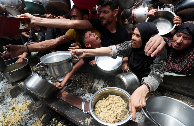 Palestinos recebendo comida em uma cozinha solidária no norte de Gaza
14/05/2025