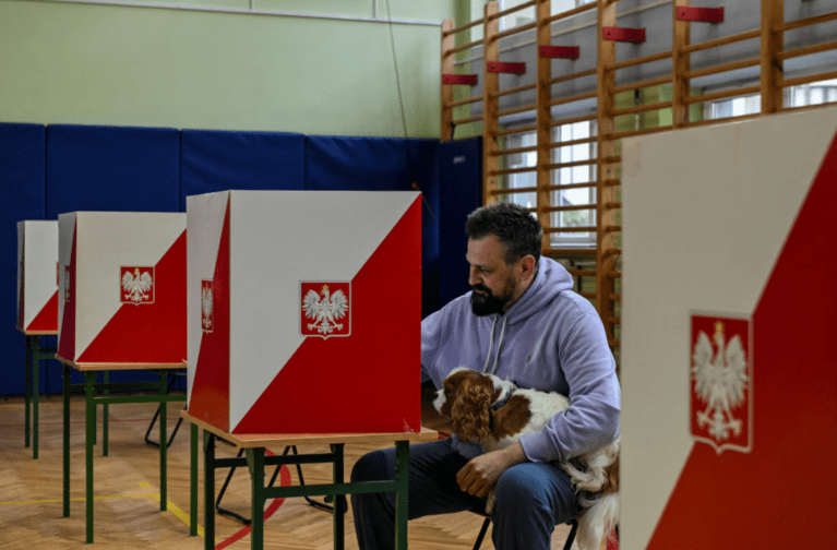 Um homem se prepara para votar durante o primeiro turno das eleições presidenciais da Polônia em uma seção eleitoral em Varsóvia, Polônia, em 18 de maio de 2025