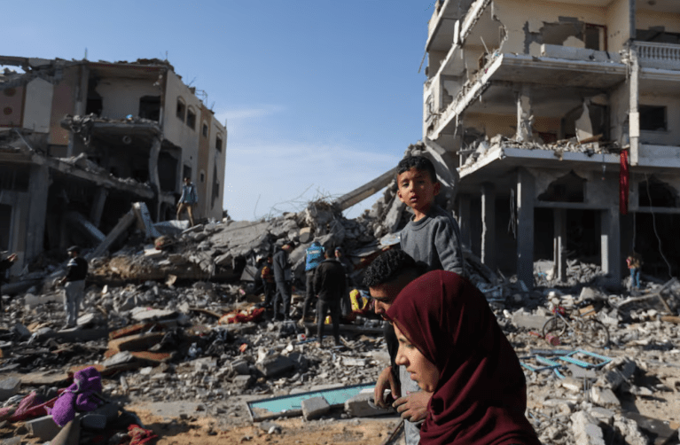 Palestinos deslocados retornam para suas casas enquanto caminham perto de casas destruídas em um ataque israelense durante o conflito, em meio à trégua temporária entre o Hamas e Israel, em Khan Younis, no sul da Faixa de Gaza, em 24 de novembro de 2023
