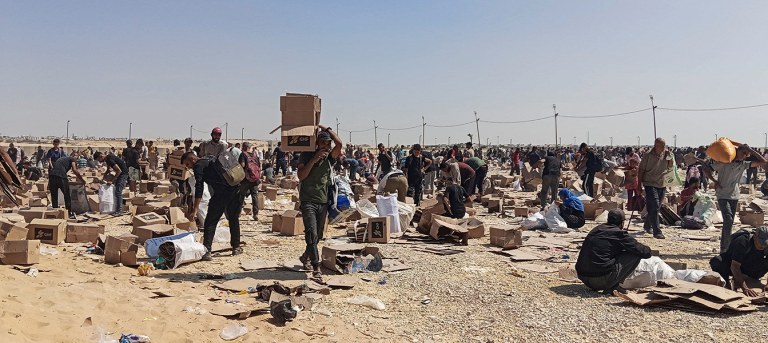 Palestinos coletam restos de suprimentos de ajuda da Fundação Humanitária de Gaza, apoiada pelos EUA, em Rafah