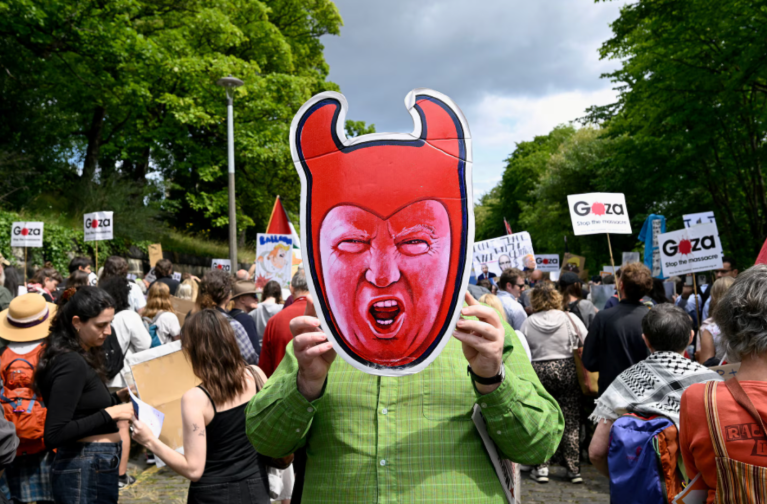 Um manifestante anti-Trump segura um recorte representando o presidente dos EUA, Donald Trump, durante um comício organizado pelo grupo de campanha "Stop Trump Coalition", protestando contra a visita de Trump, em Edimburgo, Escócia, Grã-Bretanha, em 26 de julho de 2025