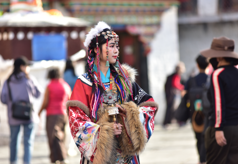 Jovem usa trajes tipicamente tibetanos