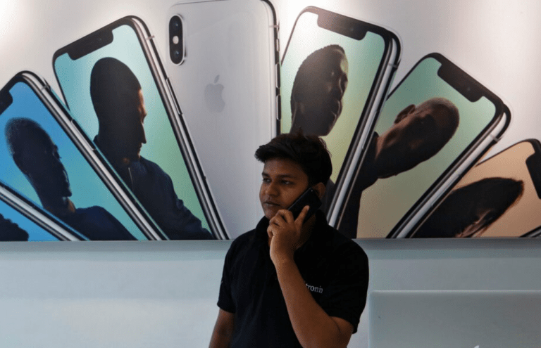 Um vendedor fala ao telefone em uma loja de revenda da Apple em Mumbai, Índia