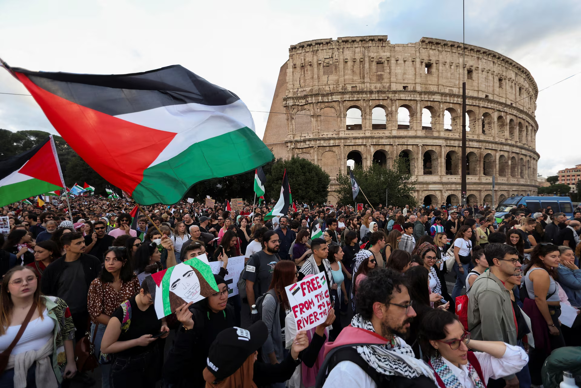 Pessoas seguram bandeiras da Palestina em frente ao Coliseu, em Roma, durante uma manifestação em apoio aos palestinos em Gaza