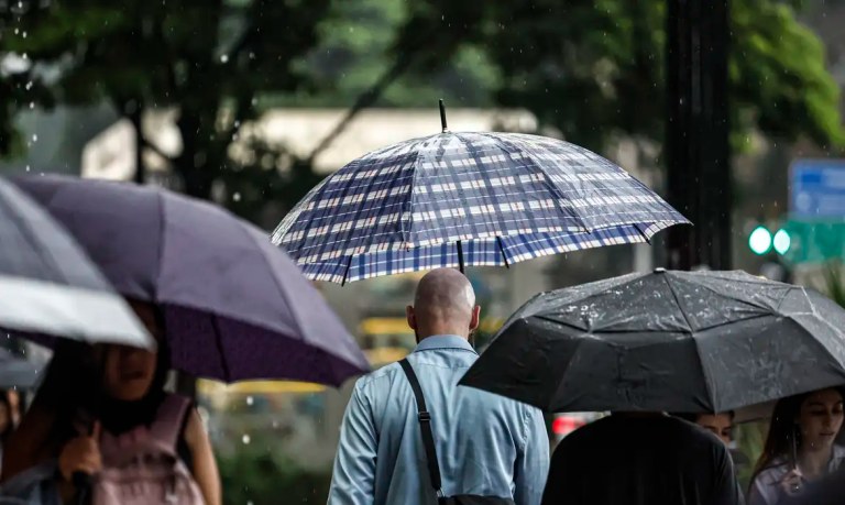 Pessoas andando e segurando guarda-chuva