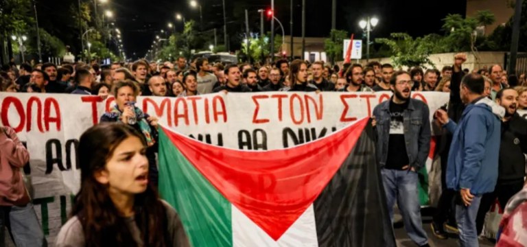 Ativistas pró-palestinos seguram uma faixa e uma bandeira palestina enquanto protestam para condenar a interceptação dos navios da Flotilha Global Sumud