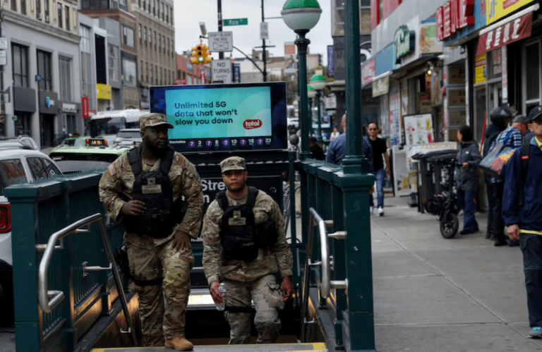 Membros da Força-Tarefa Conjunta Empire Shield, uma unidade permanente da Guarda Nacional de Nova York criada após o 11 de setembro para dissuadir e prevenir o terrorismo, fornecendo apoio militar às forças policiais civis em áreas de alto risco na cidade de Nova York, caminham em um metrô na área de Flushing, no bairro de Queens, na cidade de Nova York, EUA, em 17 de setembro de 2025.