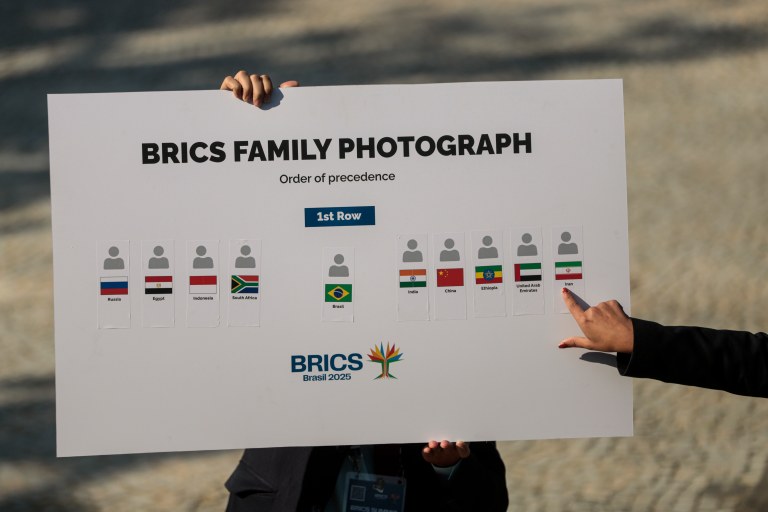 Rio de Janeiro (RJ) - 06/07/2025 - Funcionário da imprensa do BRICS mostra cartaz com posição para foto ofical durante a cúpula do bloco