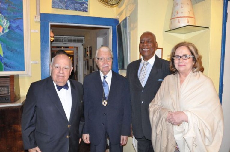 Haroldo Costa convidou para o encaminharem até a mesa da solenidade em que receberia as insígnias, seus confrades acadêmicos, o embaixador Marcos Azambuja, o pintor Israel Pedrosa e esta jornalista, Hildegard Angel.