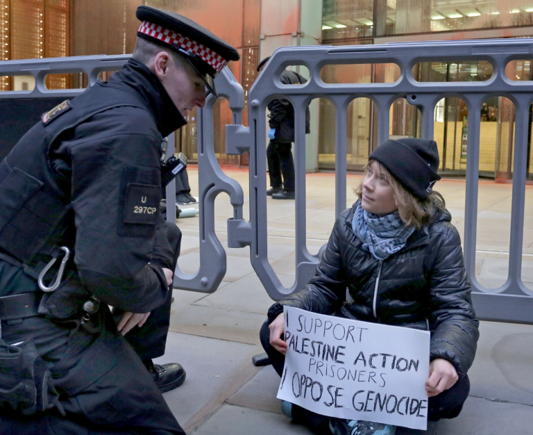 Greta Thunberg sentada em Londres, durante protesto em apoio a presos ligados ao Palestine Action, antes de ser detida pela polícia britânica