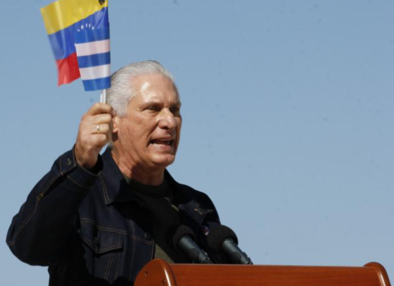 O Presidente cubano Díaz-Canel com as bandeiras de Cuba e Venezuela