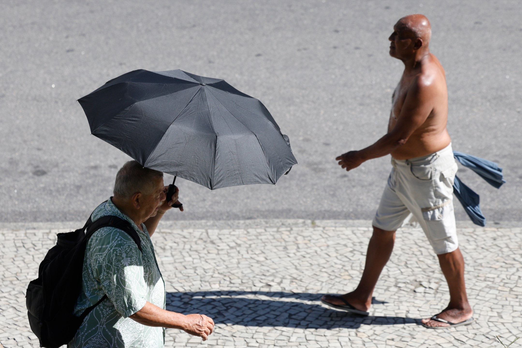 Rio de Janeiro (RJ) - 26/12/2025 - Pessoas se protegem do sol no centro da cidade em dia de calor